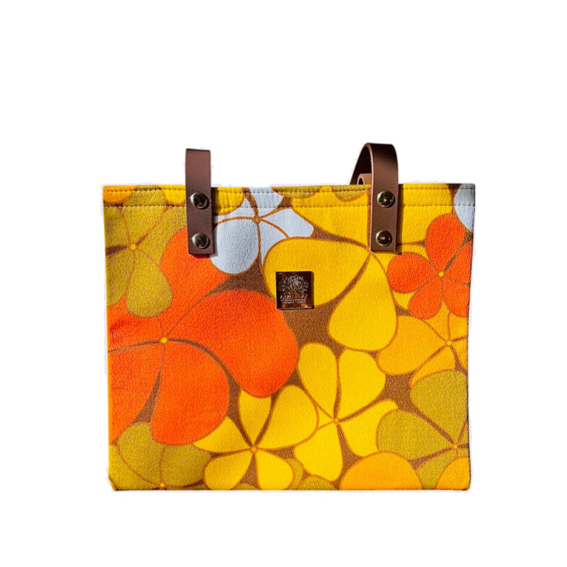 Floral-patterned bag with brown handles on a white background